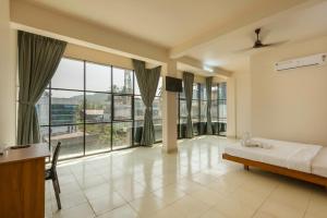 a bedroom with a bed and a large window at Grape Rooms in Perintalmanna