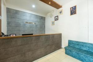 a waiting area with a blue bench in a waiting room at Grape Rooms in Perintalmanna