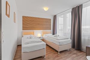 a bedroom with two beds and a window at Atelier Guesthouse in Filderstadt