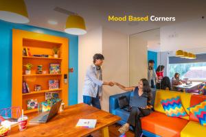 a man shaking the hand of a woman in a room at goSTOPS Bengaluru, Jayanagar - Private Rooms & Dorms in Bangalore