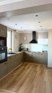 a large kitchen with wooden floors and stainless steel appliances at Apartament Izabella in Suwałki