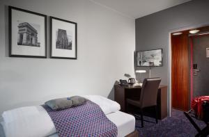 a bedroom with a bed and a desk with a chair at Hotel Cabinn Vejle in Vejle