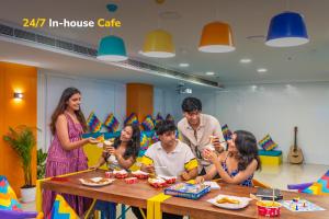 a group of people sitting around a table eating food at goSTOPS Bengaluru, Jayanagar - Private Rooms & Dorms in Bangalore +51 photos