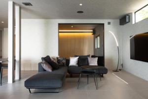 a living room with a couch and a table at eureka awaji 絶景インフィニティプール x 露天温水ジャグジー付きヴィラ in Sumoto