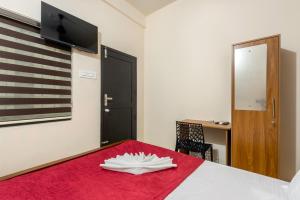 a room with a red bed with a flag on the wall at Grape Rooms in Perintalmanna