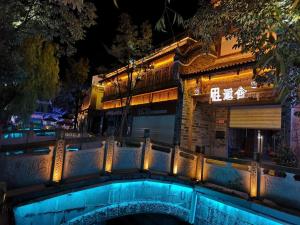 a building with a bridge over a river at night at Xianzai Houshe Boutique Hotel in Dujiangyan