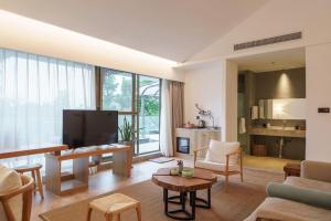 a living room with a couch and a tv at Xianzai Houshe Boutique Hotel in Dujiangyan