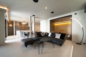 a living room with a couch and a table at eureka awaji 絶景インフィニティプール x 露天温水ジャグジー付きヴィラ in Sumoto