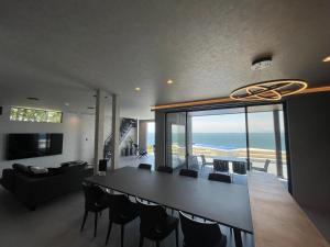 a dining room with a table and chairs and the ocean at eureka awaji 絶景インフィニティプール x 露天温水ジャグジー付きヴィラ in Sumoto