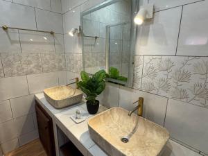 a bathroom with two sinks and a mirror at Le Passamainty Lodge in Mamoudzou +15 photos