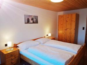 a bedroom with a bed with two night stands and two lamps at Ferienwohnung Entstrasser in Virgen
