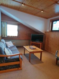 a living room with a couch and a tv at Ferienwohnung Entstrasser in Virgen