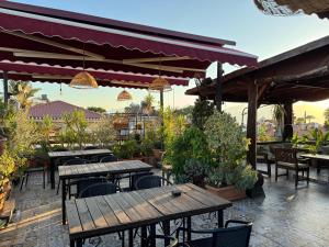 an outdoor patio with wooden tables and chairs at Gold Coast Hostel in Antalya