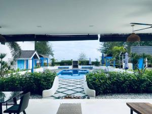 a patio with a pool and a table and chairs at Villa Alaya Malai in Setiu