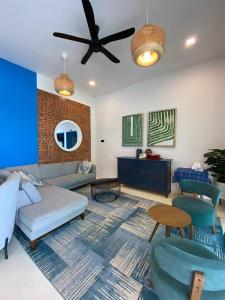 a living room with a couch and a ceiling fan at Villa Alaya Malai in Setiu