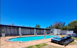a swimming pool with several rafts in front of a building at Hill Fore! in Langebaan