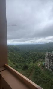a view from a window of a green field at Twin Lakes Tagaytay Staycation by JC Staycation in Balibaguhan