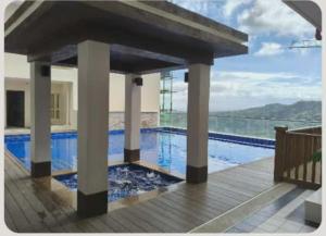 a swimming pool with a view of the water at Twin Lakes Tagaytay Staycation by JC Staycation in Balibaguhan