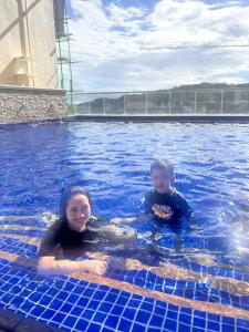 two children are swimming in a swimming pool at Twin Lakes Tagaytay Staycation by JC Staycation in Balibaguhan