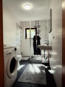 a bathroom with a washing machine and a sink at Lüttje Tied in Walsrode +12 photos