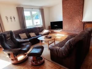 a living room with leather furniture and a brick wall at Lüttje Tied in Walsrode