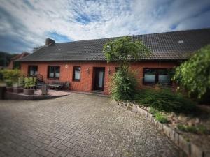 a red brick house with a brick driveway at Lüttje Tied in Walsrode