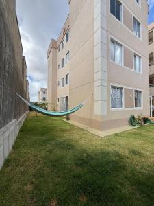 a hammock in a yard next to a building at AP da FLOR Guerra in Parnamirim