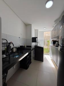 a large kitchen with a sink and a counter at AP da FLOR Guerra in Parnamirim