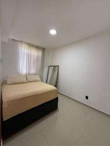 a bedroom with a bed in a white room at AP da FLOR Guerra in Parnamirim +11 photos