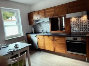a kitchen with wooden cabinets and a table and a window at Lüttje Tied in Walsrode