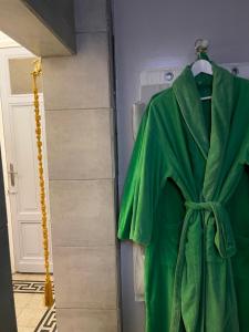a green robe hanging on a door in a bathroom at Graeco-Roman Residence-Delilah in Alexandria +92 photos