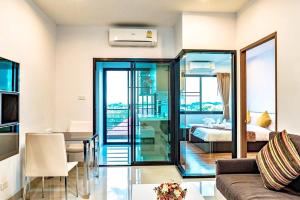 a living room with a couch and a bedroom at V-twin Condo Donjan in Chiang Mai