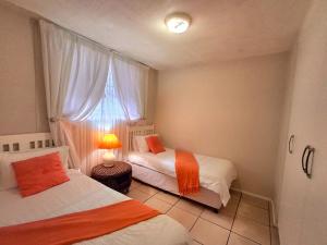 a small bedroom with two beds and a window at Margate Boulevard Beachfront Apartment in Margate