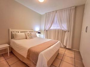 a bedroom with a large bed and a window at Margate Boulevard Beachfront Apartment in Margate