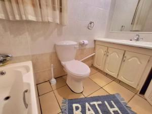 a bathroom with a toilet and a sink at Margate Boulevard Beachfront Apartment in Margate +5 photos