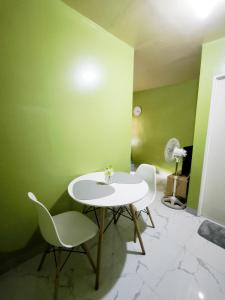 a white table and chairs in a room with green walls at Casa Uno Leyte in Palo