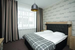 a bedroom with a bed with a checkered blanket at Pühajärve Spa & Holiday Resort in Otepää