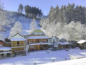 a large building in the snow with snow covered trees at Hotelový resort Šikland in Zvole