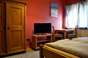 a bedroom with a bed and a flat screen tv at Apartmány u Honzy in Frýdlant nad Ostravicí