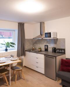 a small kitchen with a table and a table and chairs at Studio chic proche aéroport et centre-ville in Charleroi