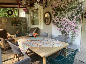 a wooden table and chairs on a patio with flowers at Chalet Luxe in Zutendaal