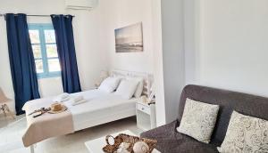 a white bedroom with a bed and a couch at Giannakis Filoxenia in Filótion
