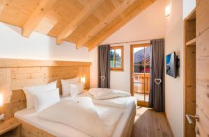 a bedroom with two beds and a window at Wellnesshüttendorf Wiese in Sankt Leonhard im Pitztal