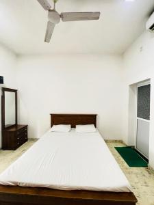 a bedroom with a white bed with a ceiling fan at Kapuwatta Pool Villa in Weligama +33 photos