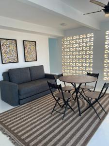 a living room with a couch and a table and chairs at Villa Alaya Malai in Setiu