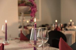 een tafel met twee wijnglazen met kaarsen erop bij Hotel Vela D'Oro in Riccione