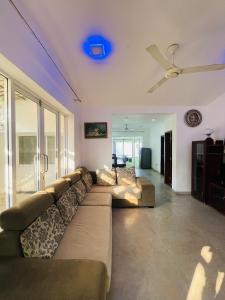 a living room with a couch and a ceiling fan at Kapuwatta Pool Villa in Weligama