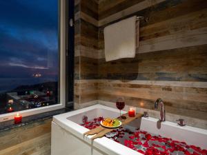 a bath tub with a plate of fruit and a glass of wine at Moustache Select Mcleodganj in Dharamshala