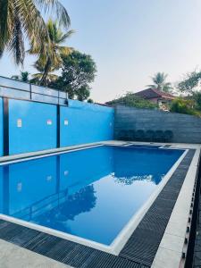a blue swimming pool next to a blue wall at Kapuwatta Pool Villa in Weligama