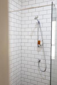 a shower with white subway tiles in a bathroom at Archers Guest House in Patentie +47 photos